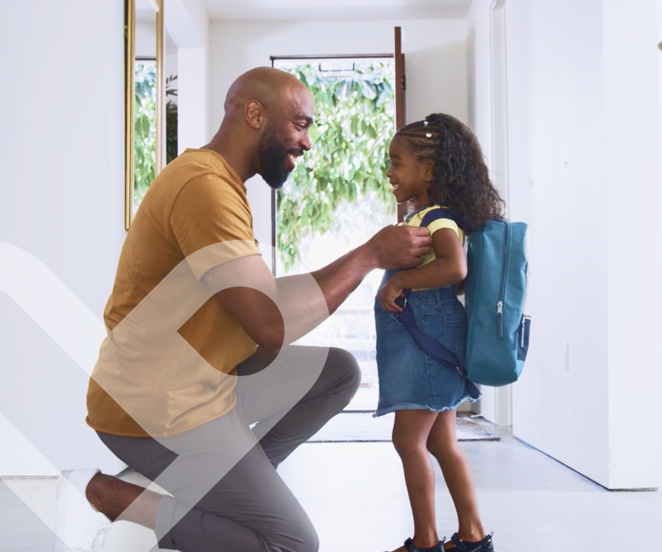 Adult kneeling down and talking to a little girl.