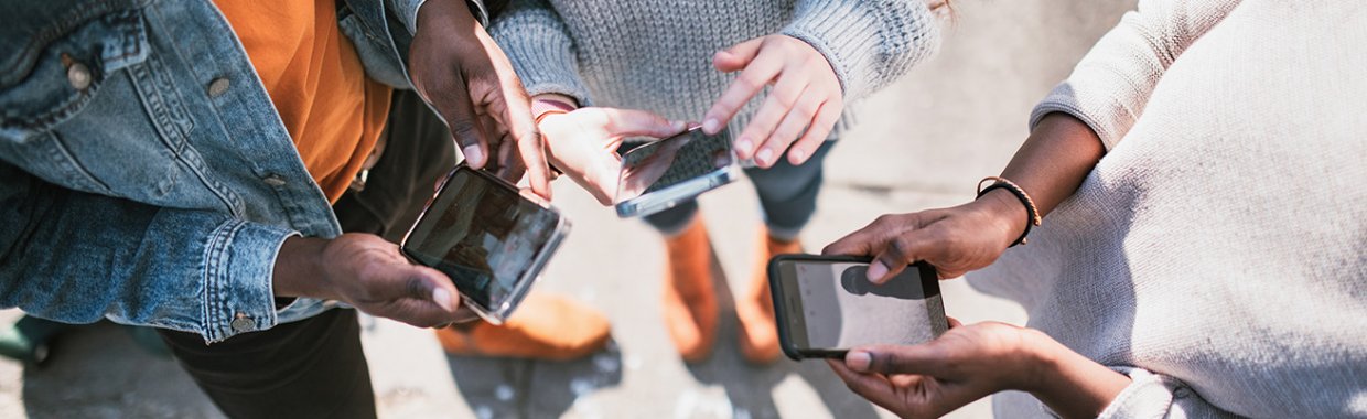 Trois personnes tenant des téléphones